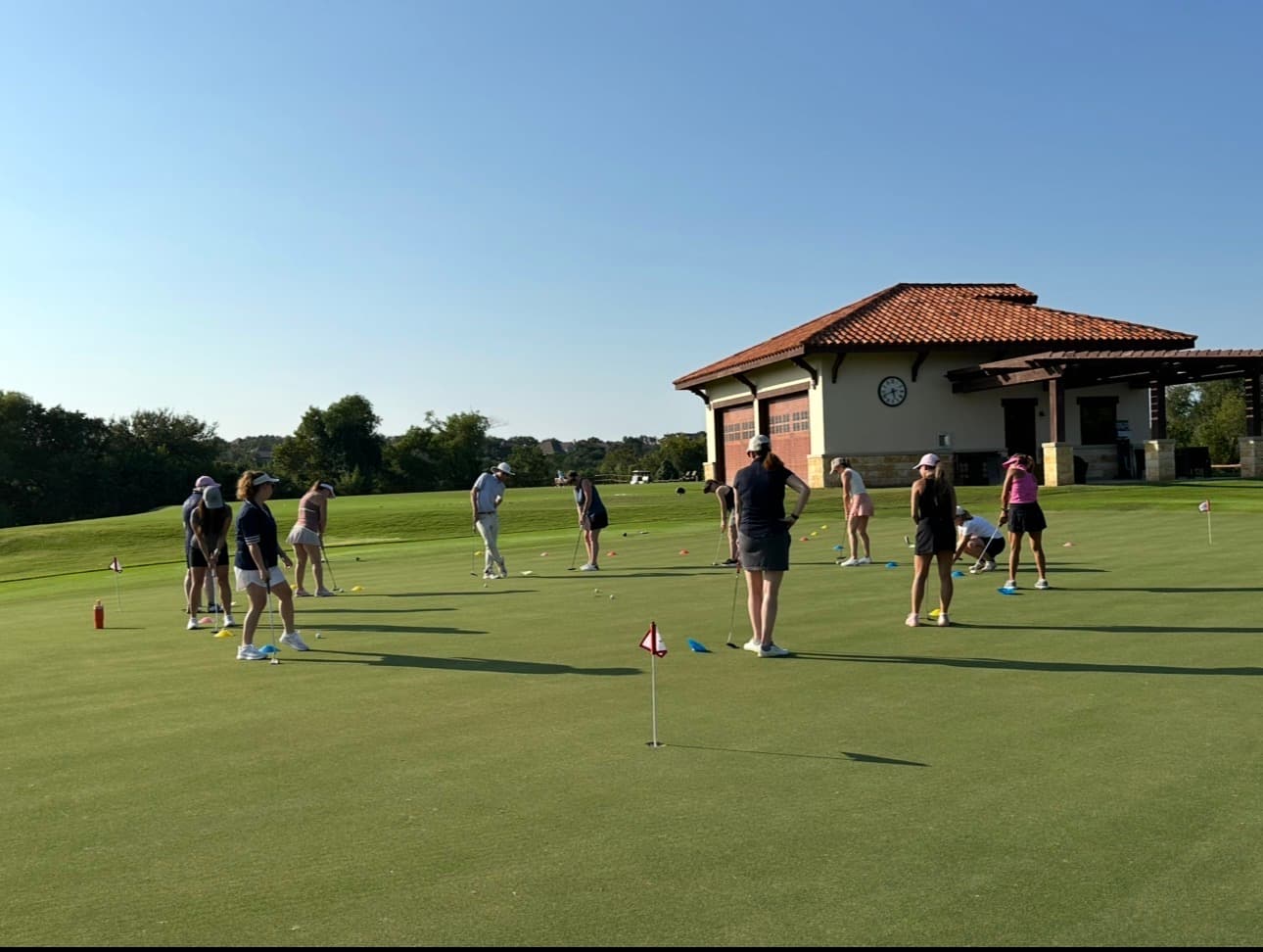 Golfers practicing on the putting green at UT Golf Club