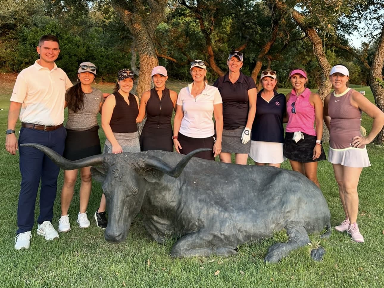 Mitchell Bozentka with an adult golf group beside the Longhorn at UT Golf Club