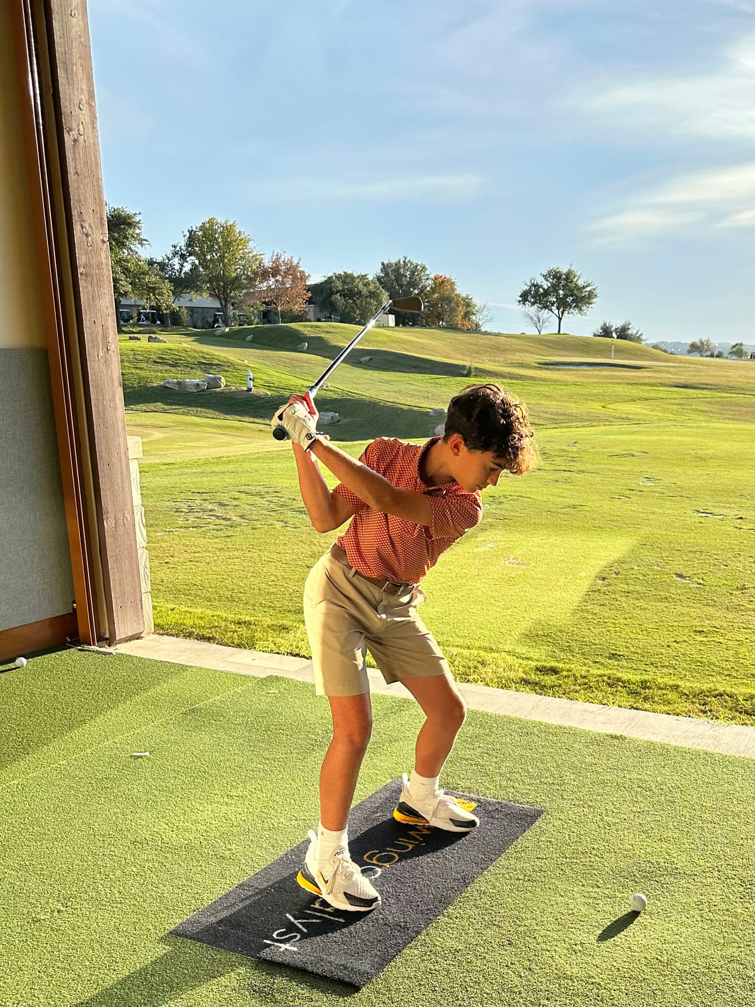 Golfer at the top of the backswing on the practice range at UT Golf Club
