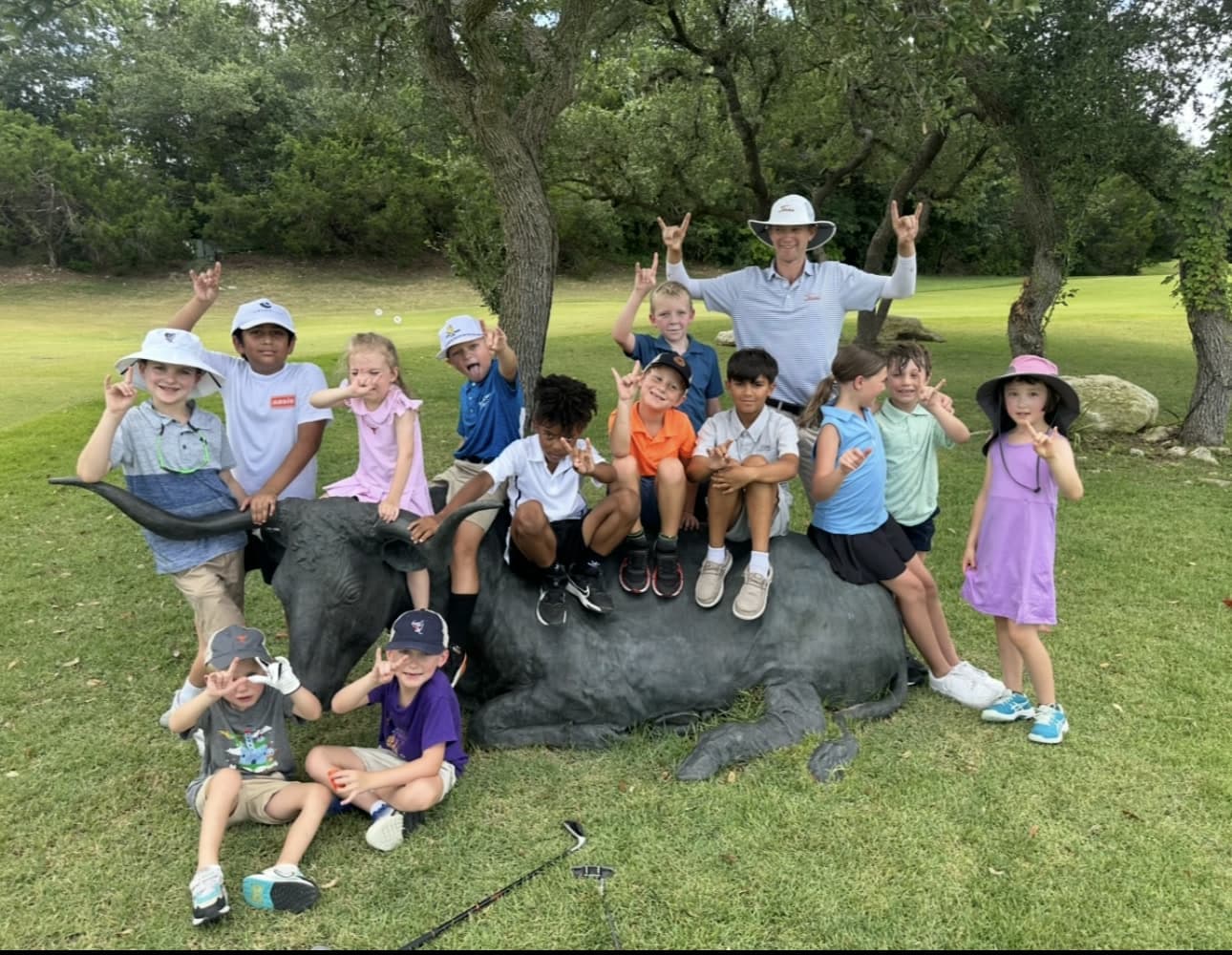 Junior golfers with Mitchell Bozentka beside the Longhorn at UT Golf Club